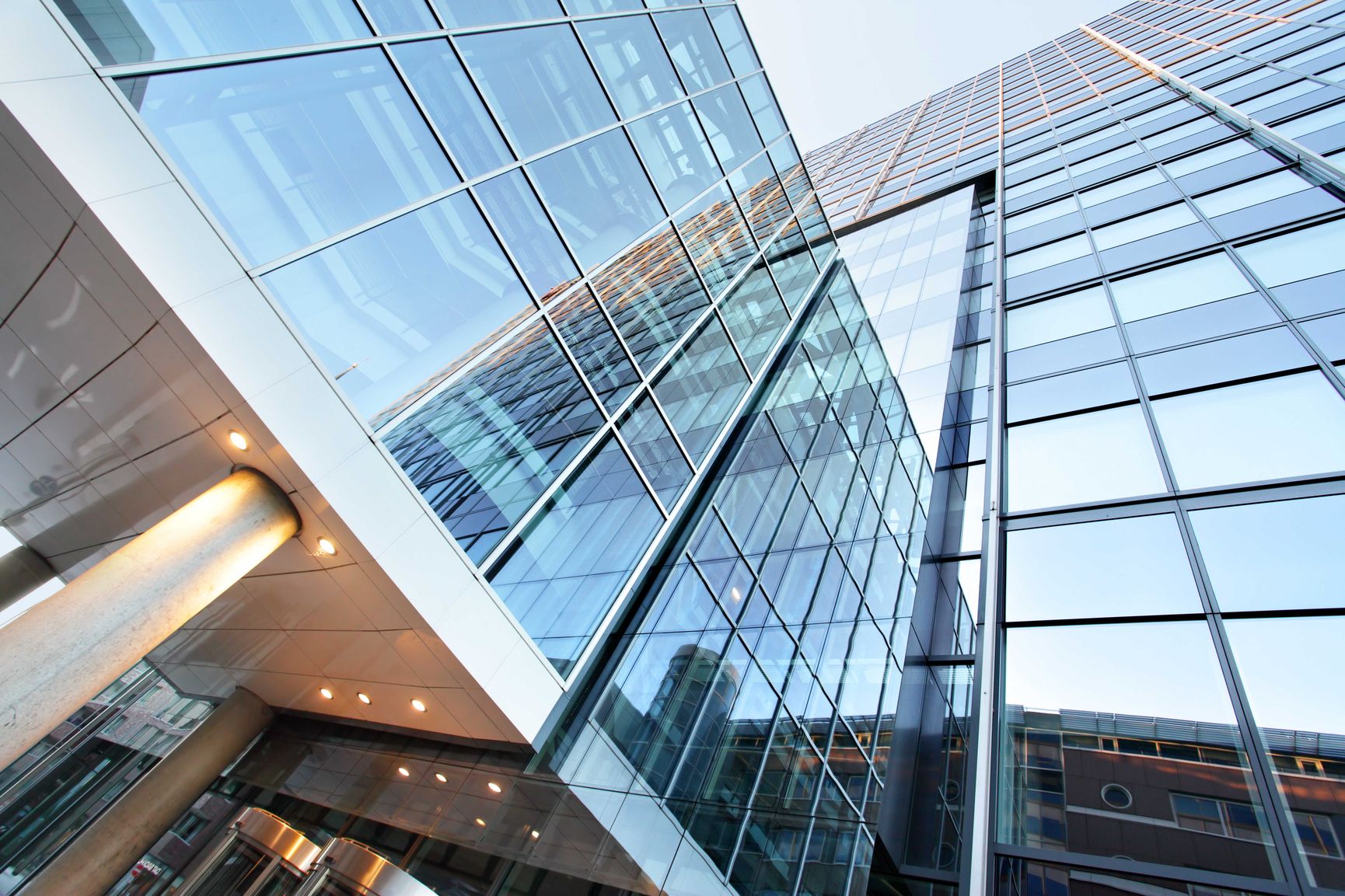 Moderne Gebäudefassade mit Glasfront und Metallelementen in der Untersicht