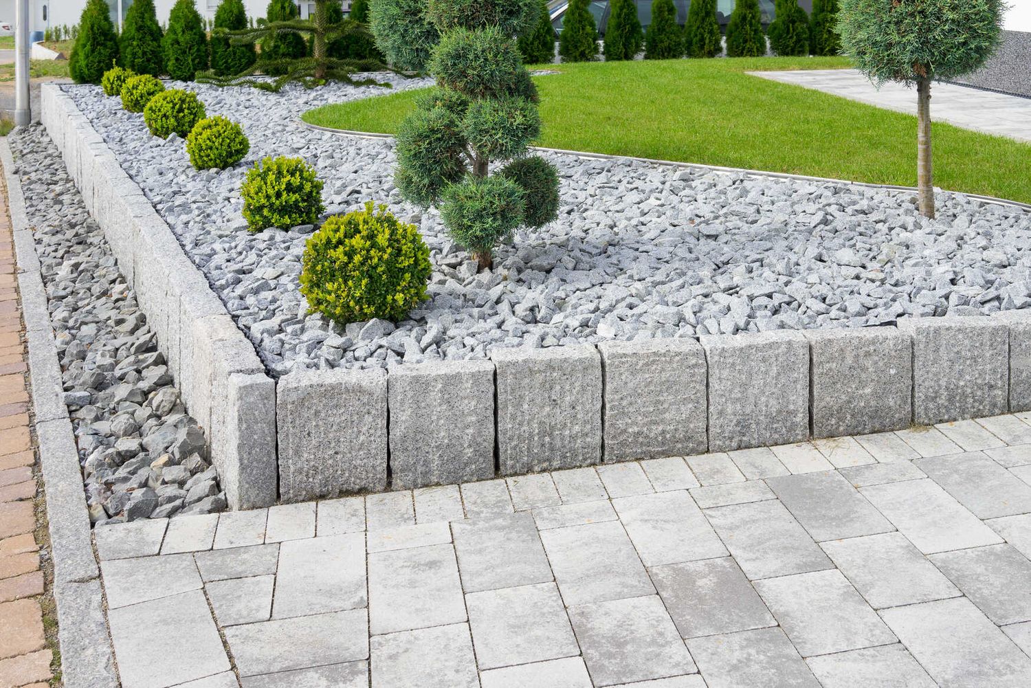 Pflasterarbeiten an einem Gartenweg mit Natursteinen